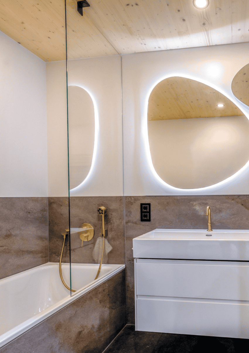 Badezimmer Melbourne: Ausschnitt zeigt Dusche und Waschbecken mit goldfarbener Armatur.