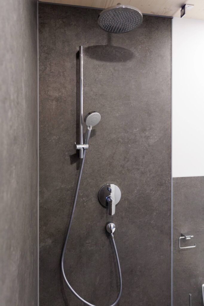 Badezimmer Inverness: Ausschnitt zeigt Dusche mit chromfarbener Armatur.