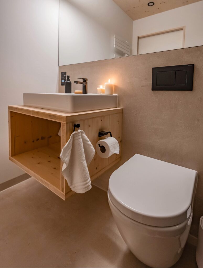 Badezimmer Osaka: Ausschnitt zeigt WC und Waschbecken mit schwarzer Armatur.