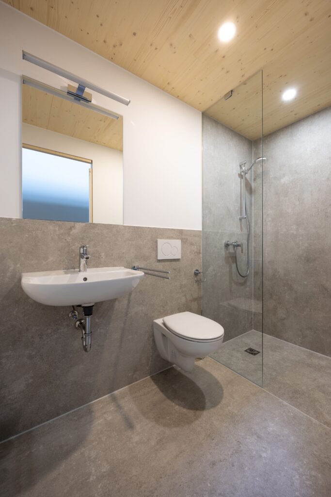 Badezimmer Stockholm: Ausschnitt zeigt WC, Dusche und Waschbecken mit chromfarbener Armatur.