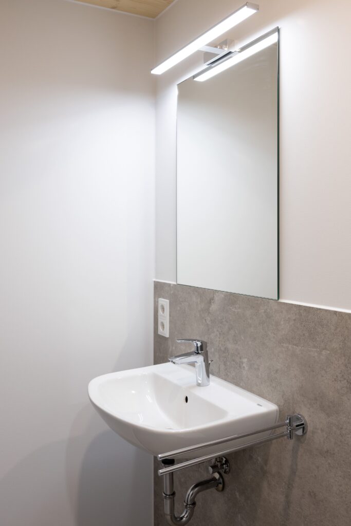 Badezimmer Stockholm: Ausschnitt zeigt Waschbecken mit chromfarbener Armatur.