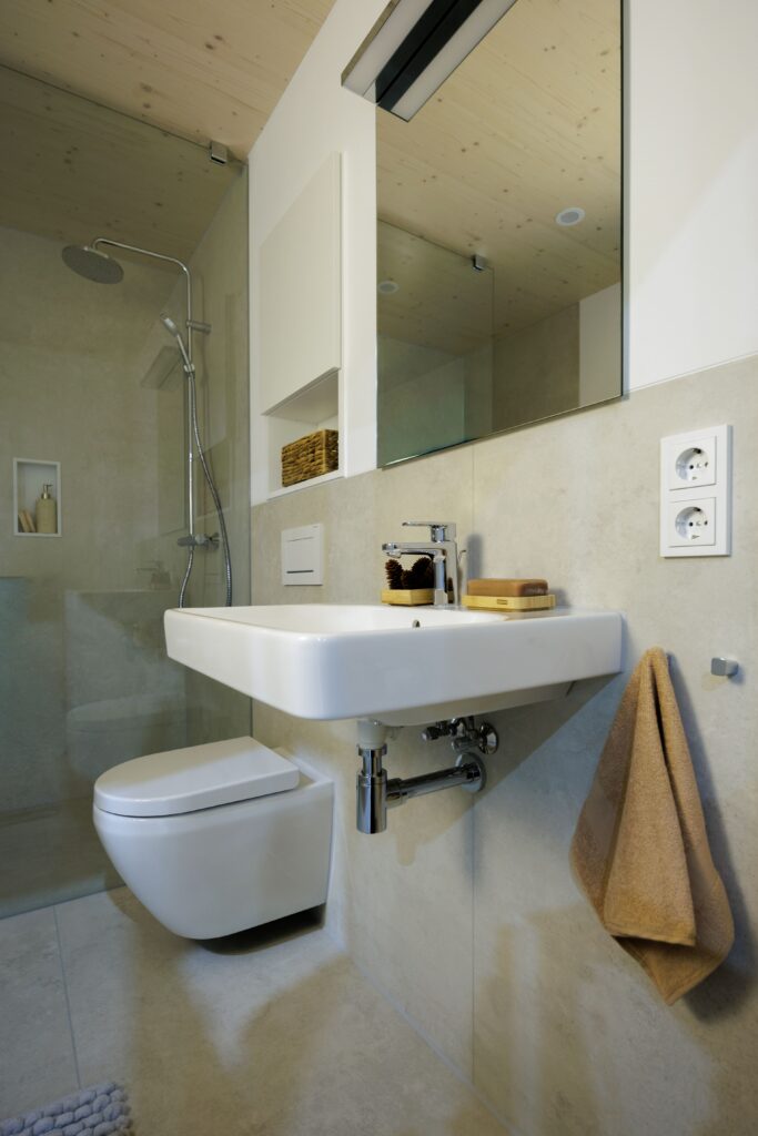 Badezimmer Vancouver: WC, Dusche und Waschbecken mit chromfarbener Armatur.